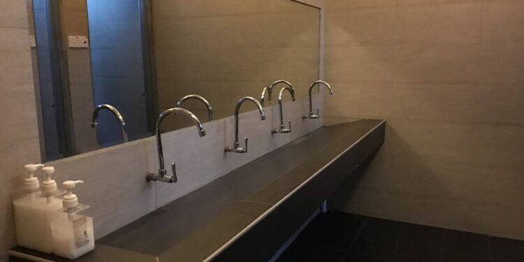 Tardaba mucho en un baño público, fueron a verlo y estaba robando las canillas